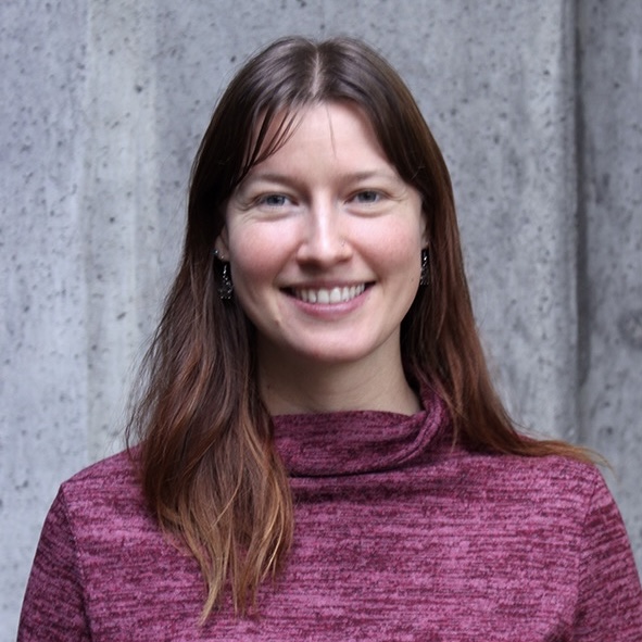 Closeup of ADC Project Manager Margaux Buehl wearing a magenta sweater and smiling.