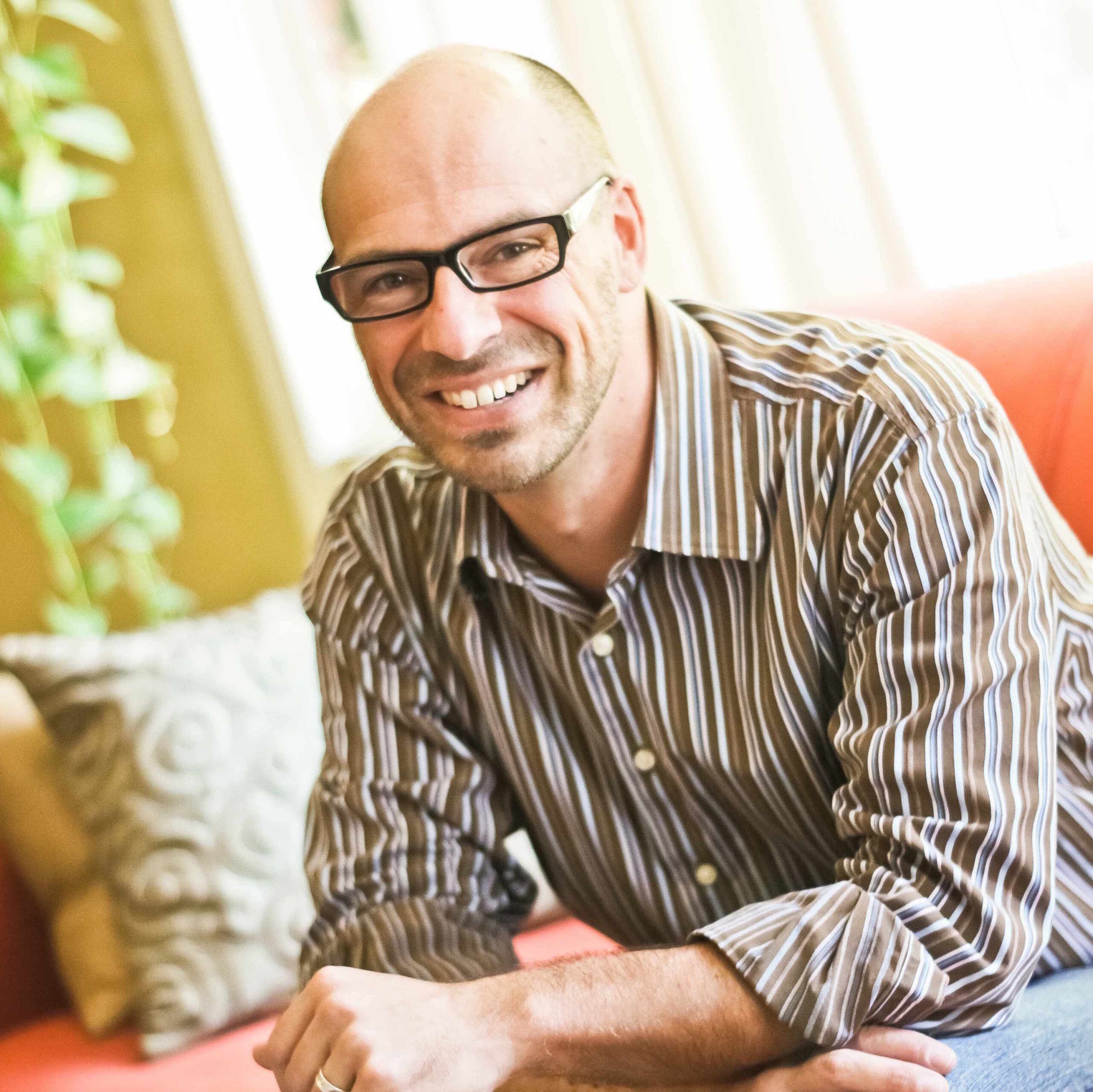 Closeup of ADC Director Chris Joyell wearing a striped shirt and smiling.