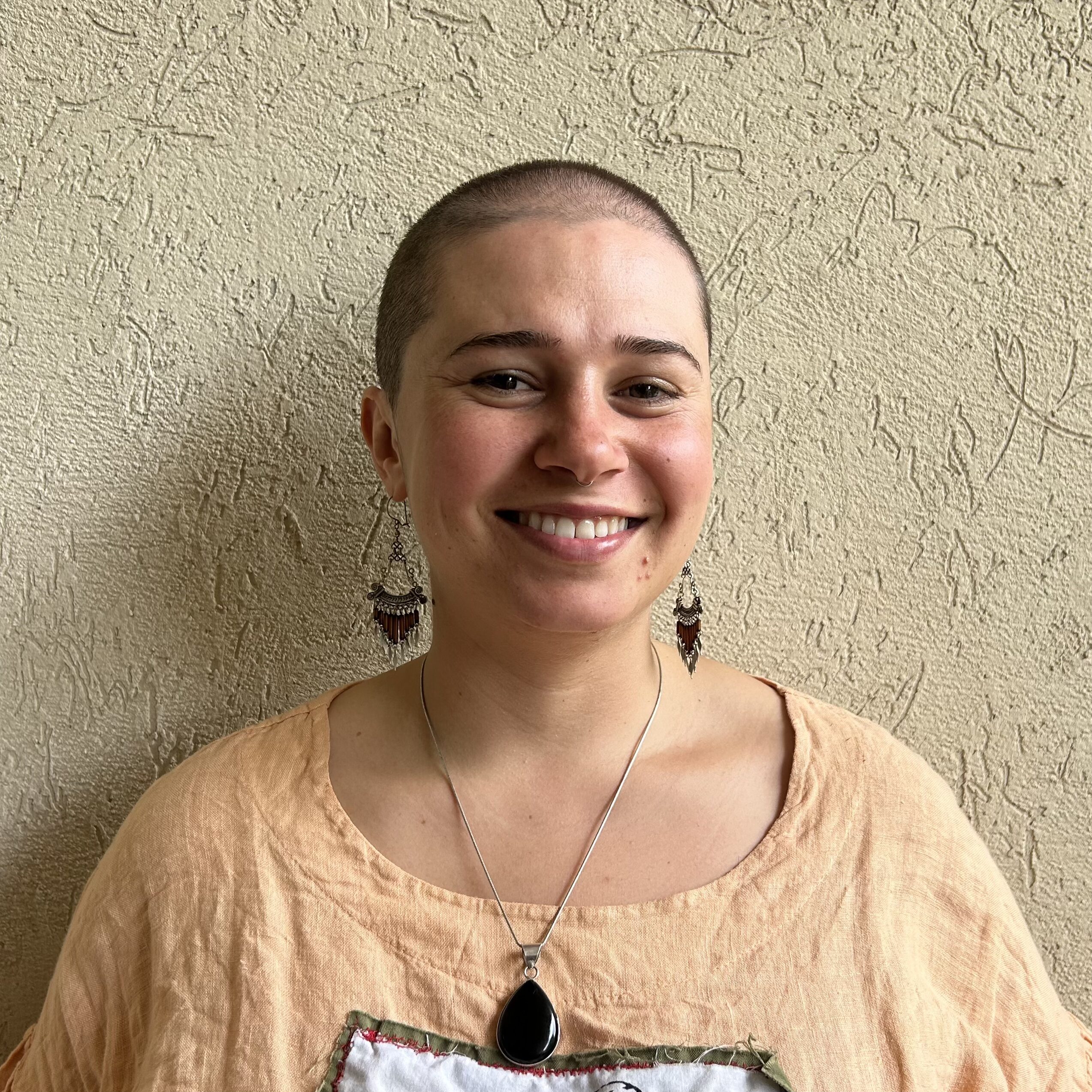 Closeup of ADC Intern Fae Elkin standing against a wall and smiling.