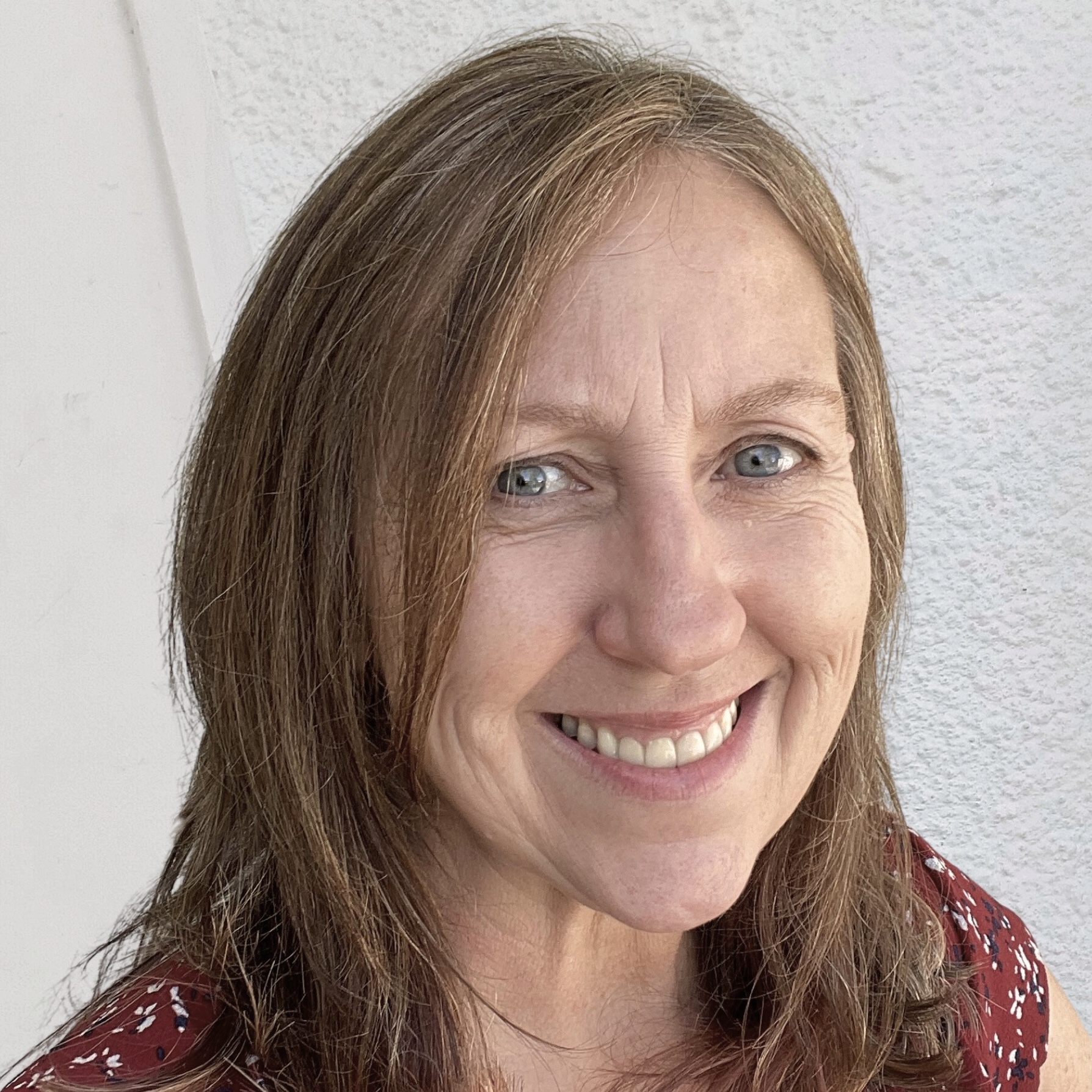 Closeup of ADC Project Manager Pat Kappes smiling with a wall behind her.